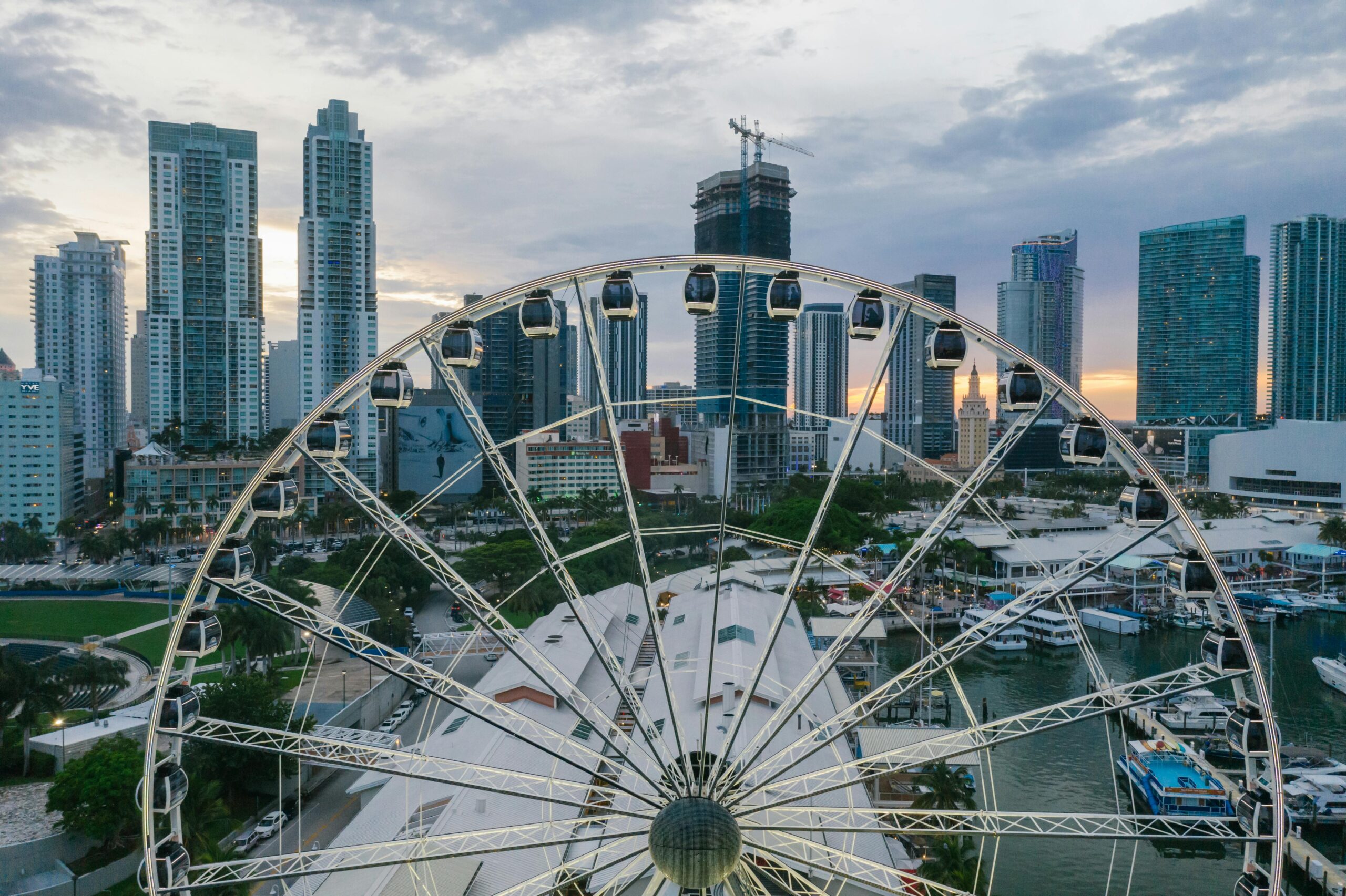 Capture the vibrant Miami skyline from a Ferris wheel at dusk, featuring high-rise buildings and colorful urban landscape.